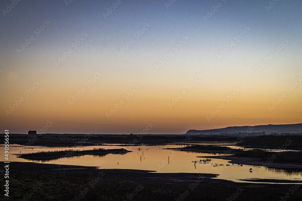 Obraz premium Sunset over Rye Harbour Nature Reserve, East Sussex, England