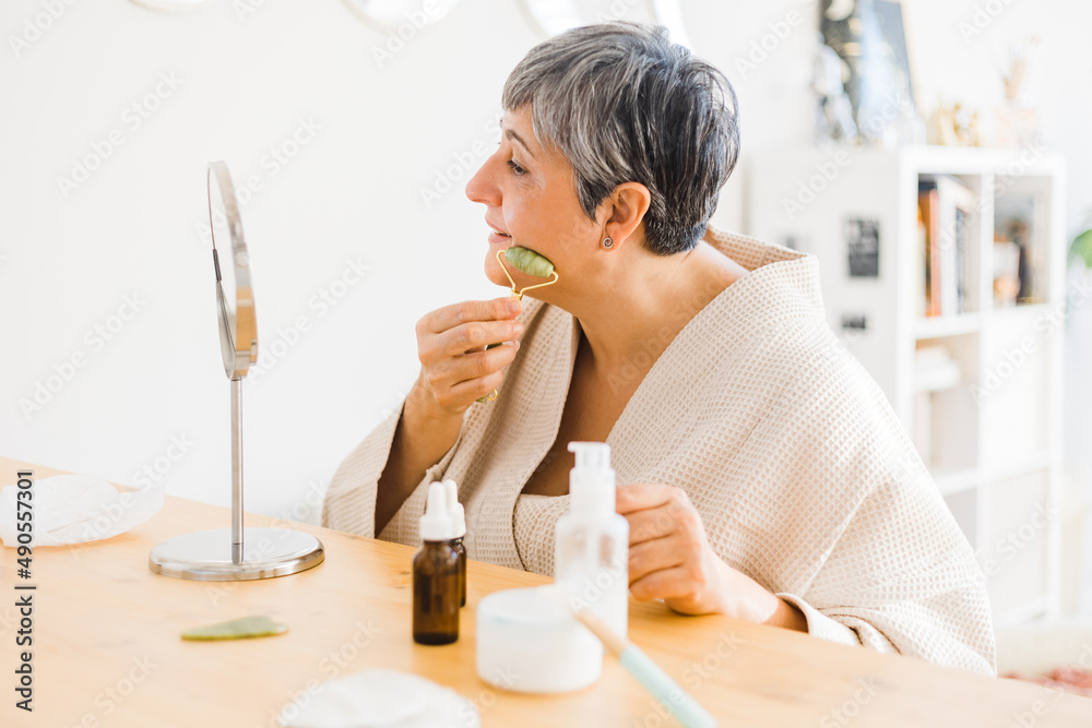 Woman massaging face during skincare procedure Woman massaging face during skincare procedure