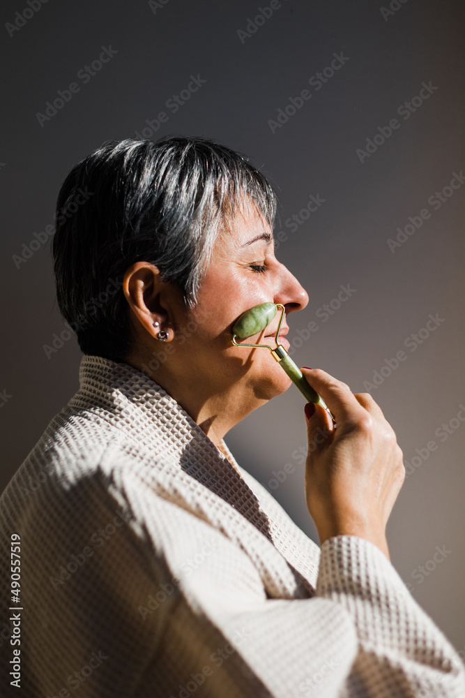Woman massaging face in room Woman massaging face in room