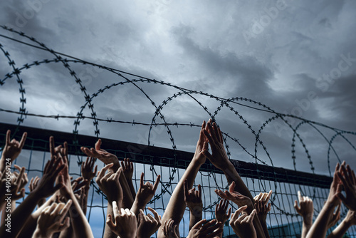 Obraz na plátně Flüchtlinge an einem Zaun - Grenze - Freiheit - Frieden