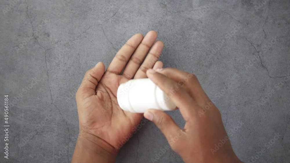 man's hand with medicine spilled out of the pill container man's hand with medicine spilled out of the pill container