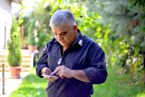 older man talking on cellphone close up, grandfather chatting with relatives or grandchildren, mature male making or answering phone call, having pleasant conversation.
