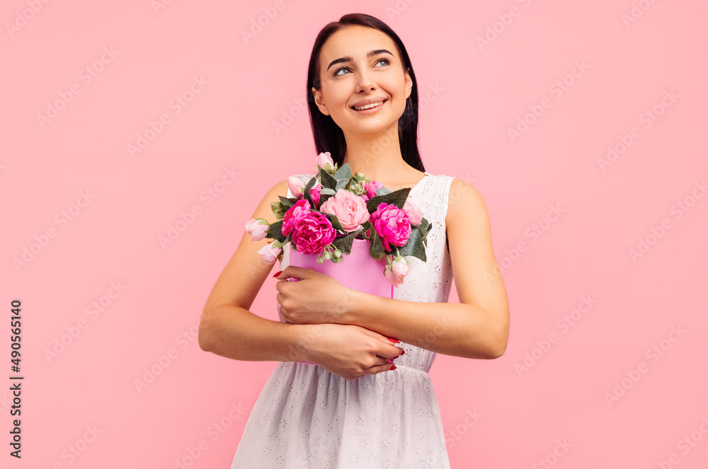 woman with rose flowers in her hands. Woman on a pink background, celebrating mother's day. March 8. woman with rose flowers in her hands. Woman on a pink background, celebrating mother's day. March 8.