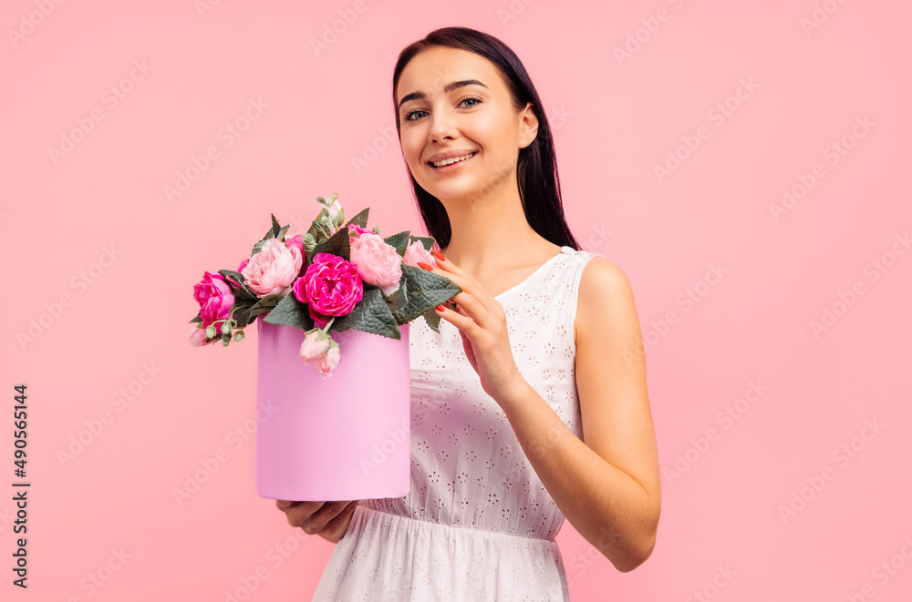 woman with rose flowers in her hands. Woman on a pink background, celebrating mother's day. March 8. woman with rose flowers in her hands. Woman on a pink background, celebrating mother's day. March 8.