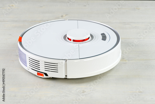 robot vacuum cleaner on the wooden floor cleaning the room. Smart cleaning and washing technology. advanced robot work to vacuum then mop. close up