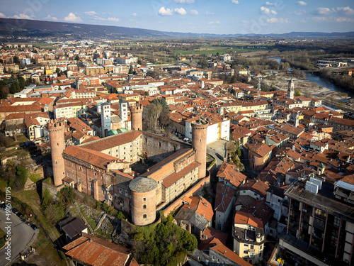 Aerial view of the historic centre with the Castle with its red towers in the foreground. Ivrea, Italy - March 2021
