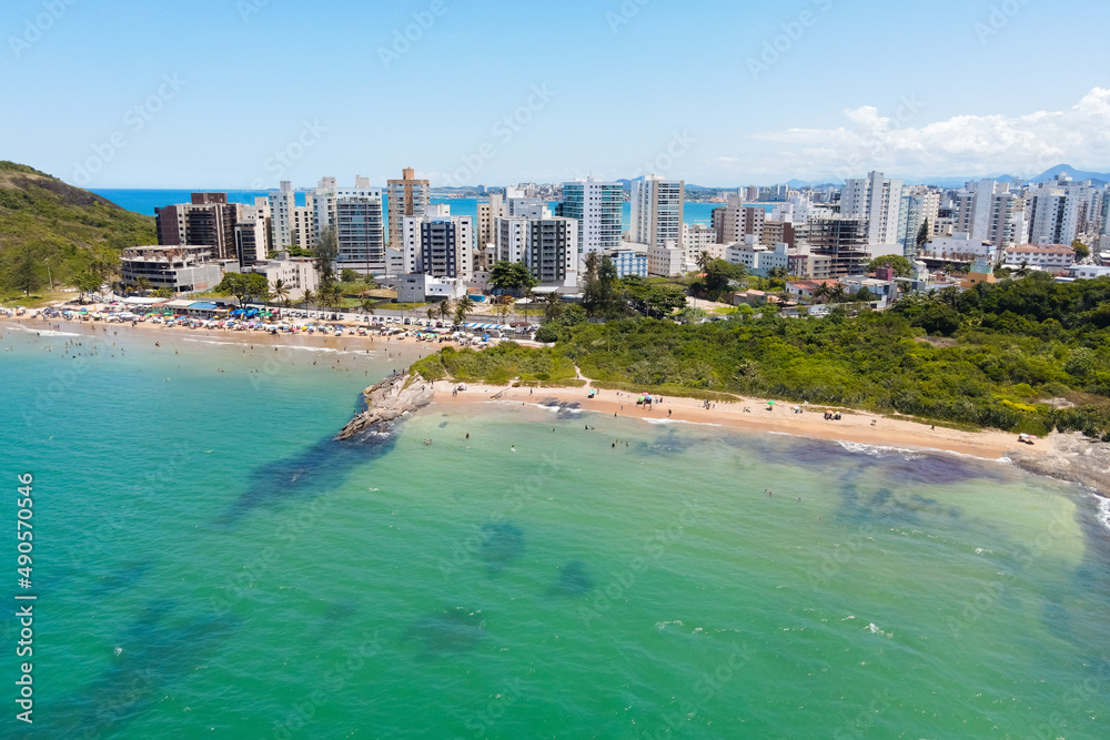Imagem aéreas da Praia da Cerca, linda praia de águas claras e mar manso na região central de Guarapari. Dia ensolarado com praia lotada de barraquinhas, pessoas descansando e praticando esportes. Imagem aéreas da Praia da Cerca, linda praia de águas claras e mar manso na região central de Guarapari. Dia ensolarado com praia lotada de barraquinhas, pessoas descansando e praticando esportes.