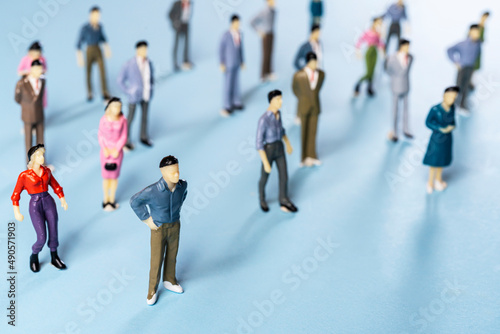 a group of miniature people on a colored surface 