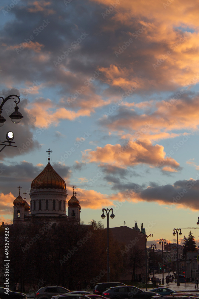 The most beautiful church with golden domes on the background of a bright sunset
