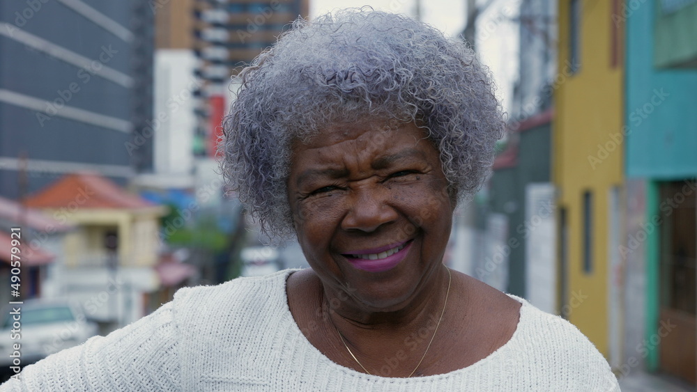 A senior woman portrait smiling at camera standing in a south american street A senior woman portrait smiling at camera standing in a south american street
