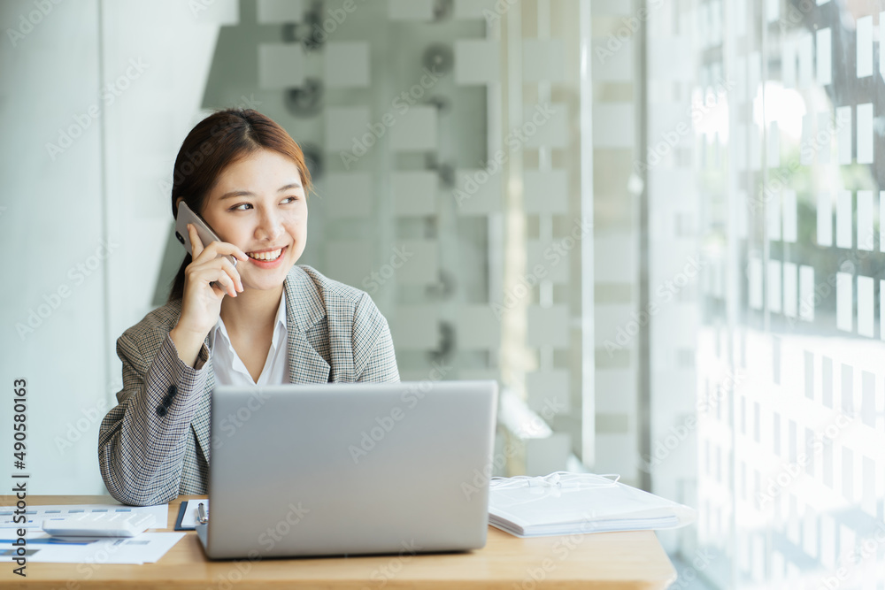 Closeup image of a beautiful asian woman holding and using mobile phone in office, business financial and investment concpet. Closeup image of a beautiful asian woman holding and using mobile phone in office, business financial and investment concpet.