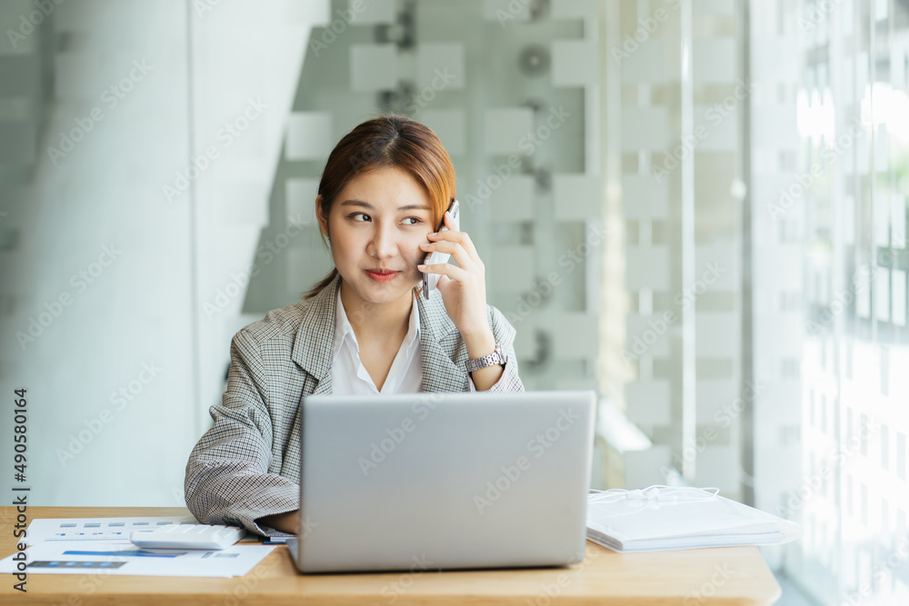Closeup image of a beautiful asian woman holding and using mobile phone in office, business financial and investment concpet. Closeup image of a beautiful asian woman holding and using mobile phone in office, business financial and investment concpet.