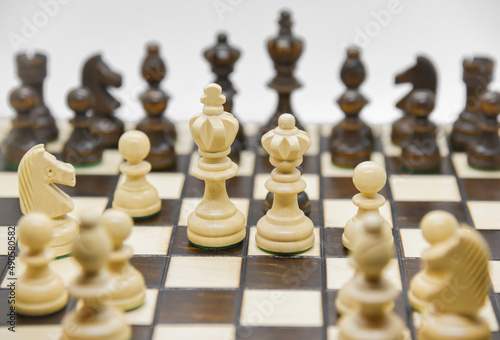 Black and white wooden figures for chess on the board