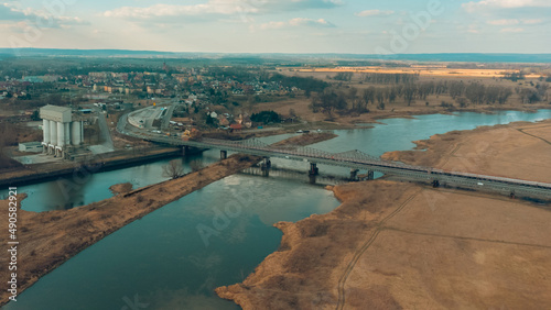 Blue railway bridge over the river Oder, Scinawa, Poland. City view area drone photo