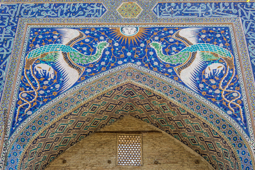 Close-up view of portal decorations of Nadir Divan-begi madrasah. In addition to classical patterns, facade is decorated with images of mythical Simurgh birds and sun. Shot in Bukhara, Uzbekistan