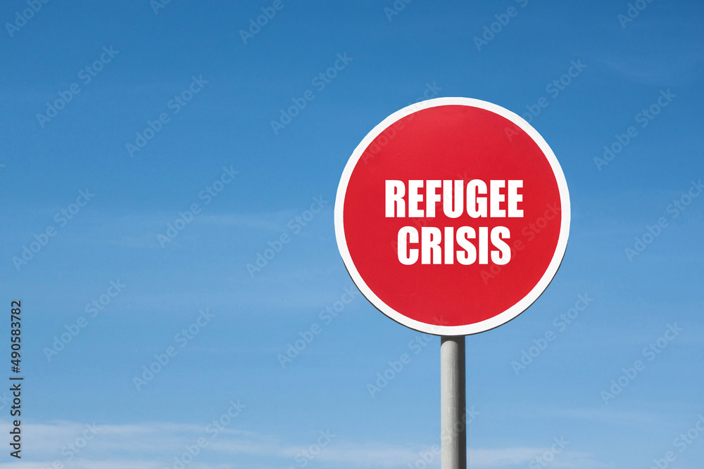 'Refugee crisis' sign in red round frame. Blue sky background 'Refugee crisis' sign in red round frame. Blue sky background