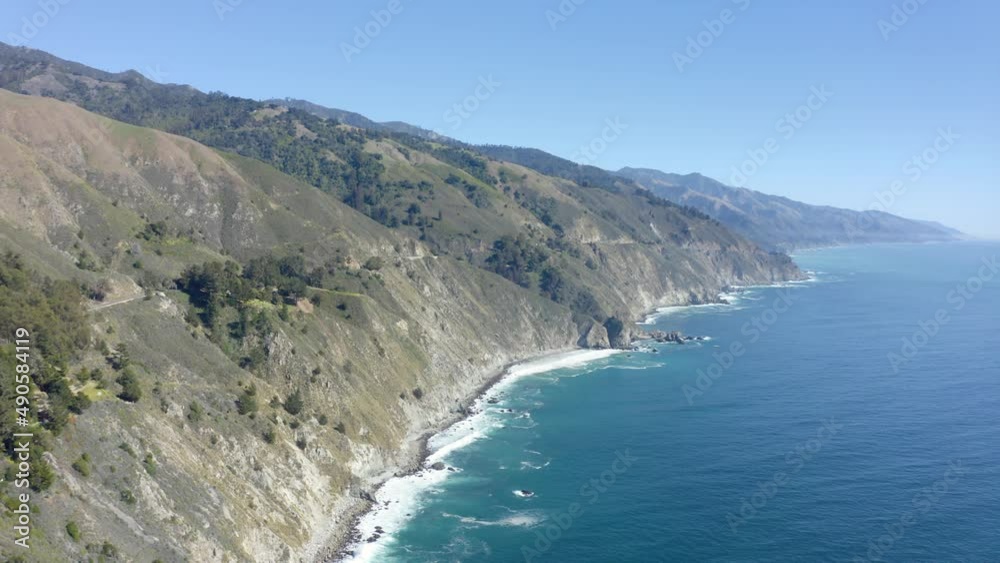 View of the road along the coast from the drone. Travel by car in summer time. The sea coast and the road. The coast of USA. Aerial view of a road running between a mountain and the ocean. View of the road along the coast from the drone. Travel by car in summer time. The sea coast and the road. The coast of USA. Aerial view of a road running between a mountain and the ocean.