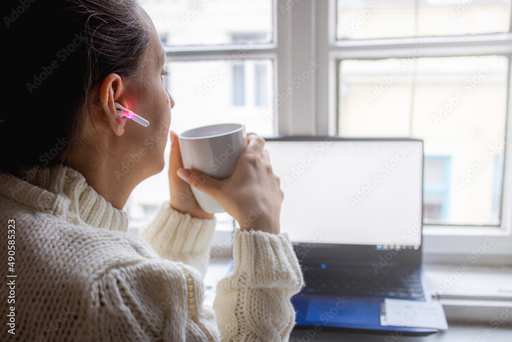 Young woman enjoying coffee while listening to music at home