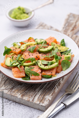 Fresh salmon salad with avocado, for keto and low carb diet. Rusty background, top view, copy space.