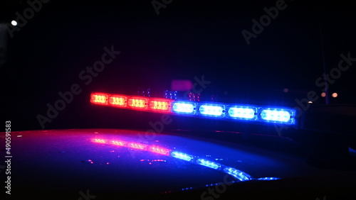 Police emergency lights flash at night. Car accident. Crime scene. Flashing blue and red lights on patrol car. 