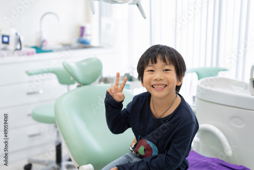 The Asian boy feel happy to sit on the dental chair in dental clinic