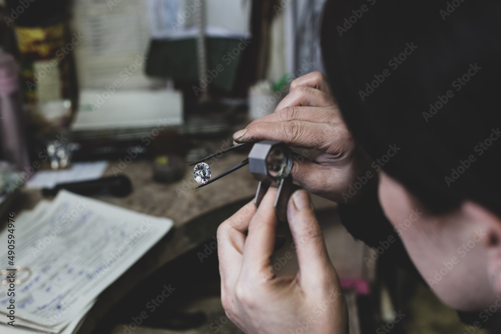 a jeweler examines a diamond