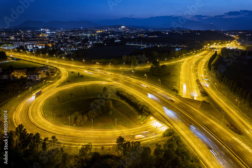 Aerial view of illuminated ..highway intersection with urban traffic speeding on the road at night.