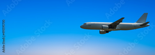 airplane flying with blue sky - horizontal banner