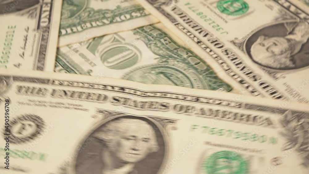 one dollar bills rotate around the axis, background, selective focus one dollar bills rotate around the axis, background, selective focus