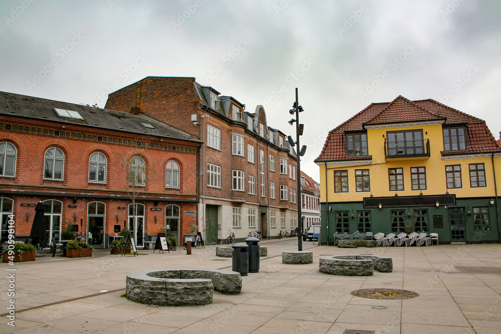 Historic buildings including shops, bars and restaurants surrounding Toldbod Plads square which is located in the heart of Aalborg near the waterfront, Denmark.
