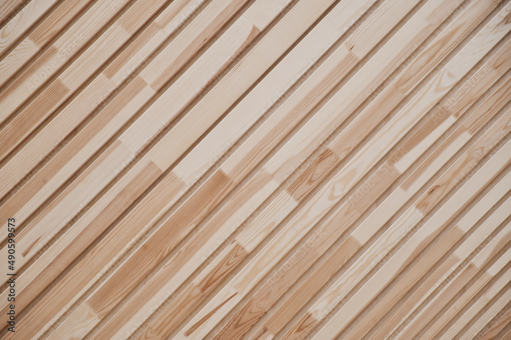Close-up of clapboard wall. Fragment of diagonal wooden planks. Decorating material. Wood texture as background. Close-up of clapboard wall. Fragment of diagonal wooden planks. Decorating material. Wood texture as background.