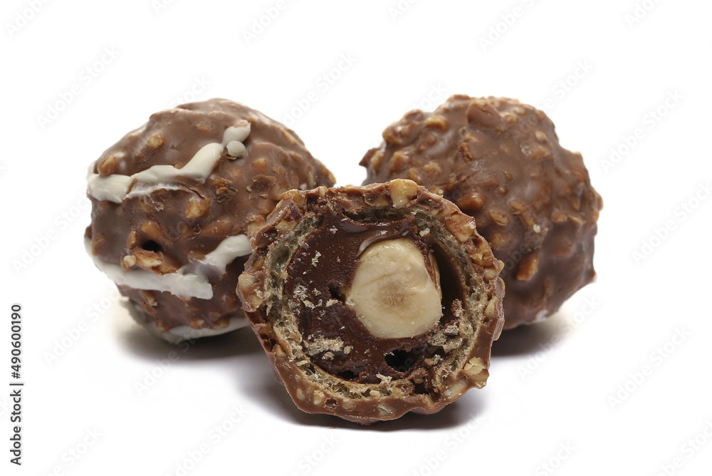 Round, half, hazelnut chocolates isolated on white Round, half, hazelnut chocolates isolated on white