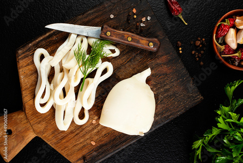 Slicing of boiled calamar on a cook-table