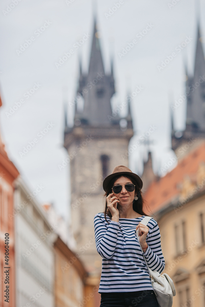 Happy young woman in hat on the street of european city.
