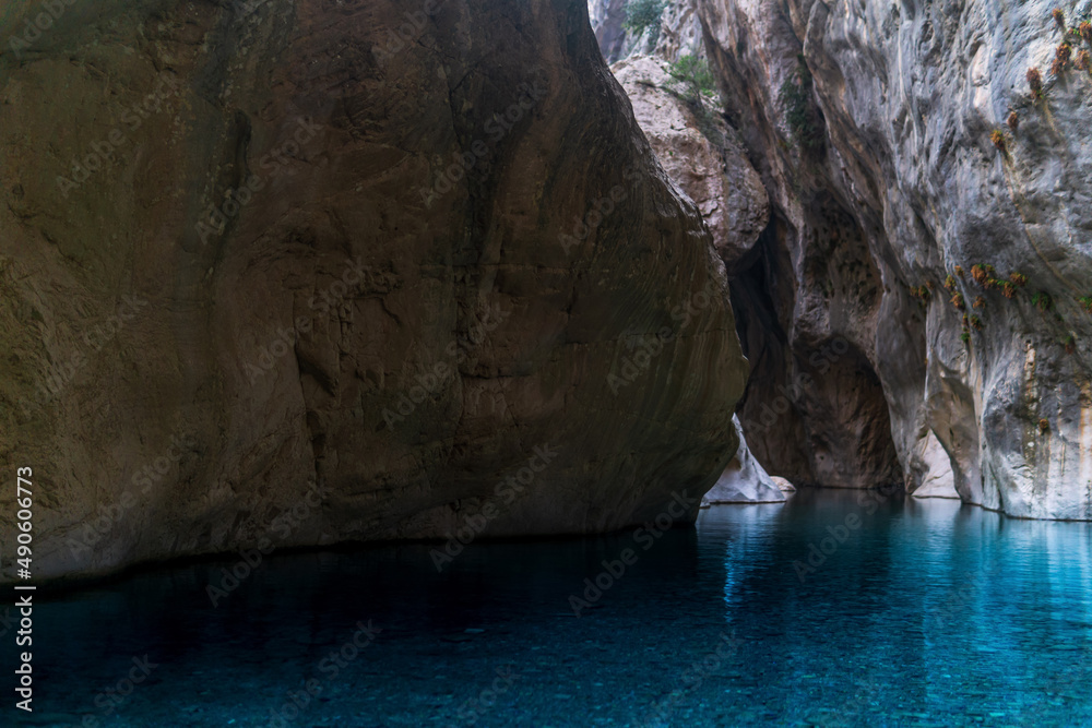 clear blue water in a deep canyon with sheer rock walls