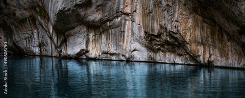 clear blue water in a deep canyon with sheer rock walls © Evgeny
