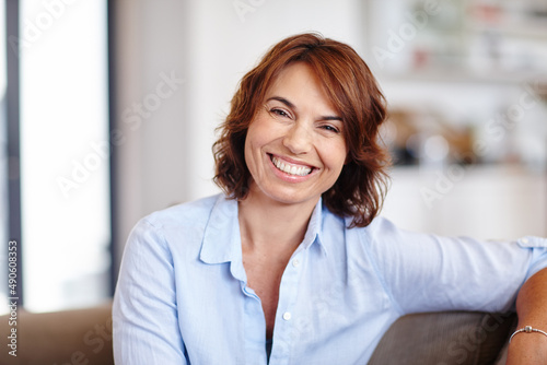 Free Download Happiness is time spent at home. Portrait of a mature woman sitting on her sofa at home. - GFXLoad