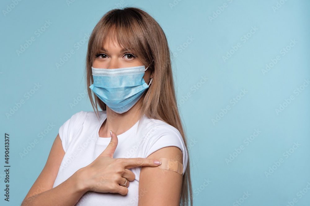 Woman Got Vaccinated Against Covid-19. Female shows vaccinated arm motivates to vaccinate against coronavirus to stop epidemic. Girl in protective mask shows shoulder with adhesive tape. Health care Woman Got Vaccinated Against Covid-19. Female shows vaccinated arm motivates to vaccinate against coronavirus to stop epidemic. Girl in protective mask shows shoulder with adhesive tape. Health care