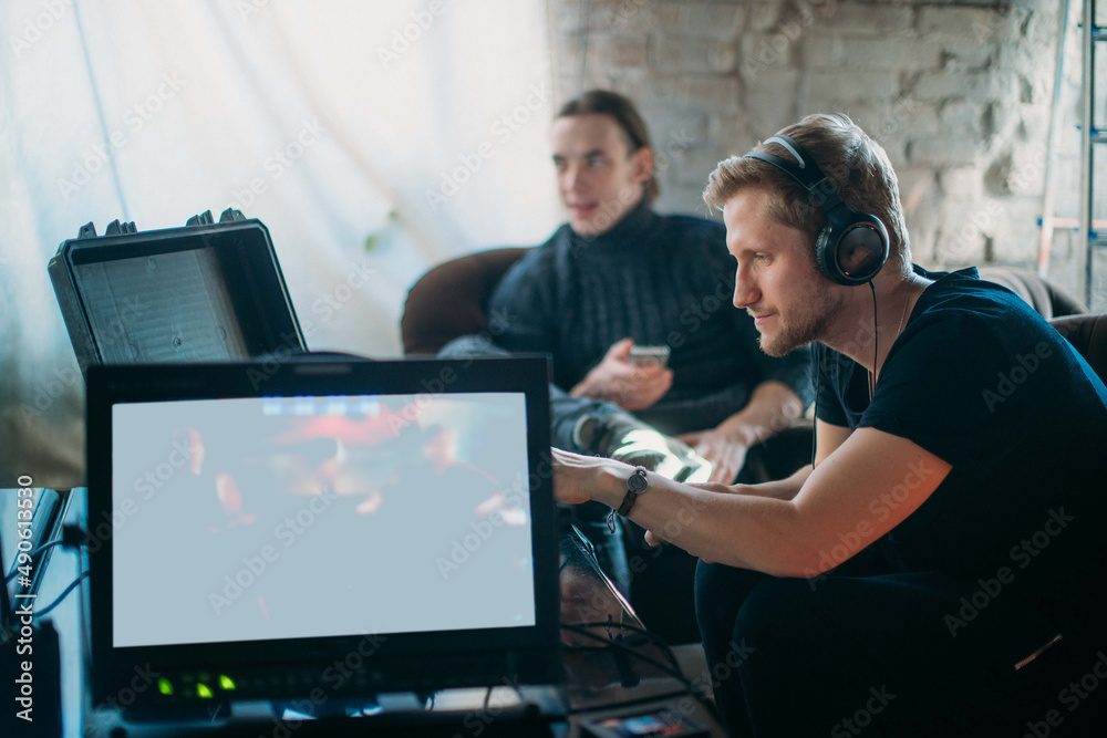 Sound engineer with a microphone on the set. A professional sound engineer at work on the filming of a movie, commercial or TV series. Sound engineer with a microphone on the set. A professional sound engineer at work on the filming of a movie, commercial or TV series.