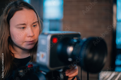 A young female director of photography at work behind a movie camera on a film set for a movie, commercial or broadcast