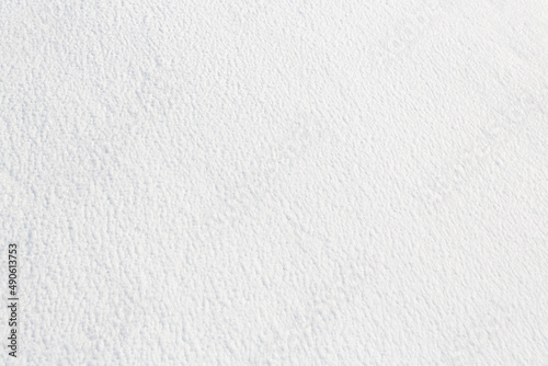 Natural snow texture. Smooth surface of clean fresh snow. Snowy ground. Winter background with snow patterns. Perfect for Christmas and New Year design. Closeup top view.