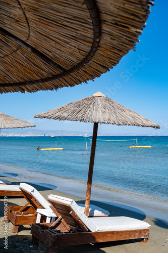Beach unbrellas and chairs on sunny sandy beach Lady's mile in Akritori, Cyprus photo