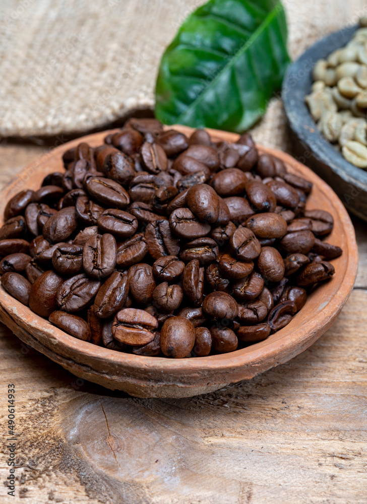 Fototapeta premium Green un-roasted and brown roasted coffee beans from Africa coffee producing region, cultivating in Ethiopia, Ivory Coast, Uganda, Kenya, Rwanda and Tanzania