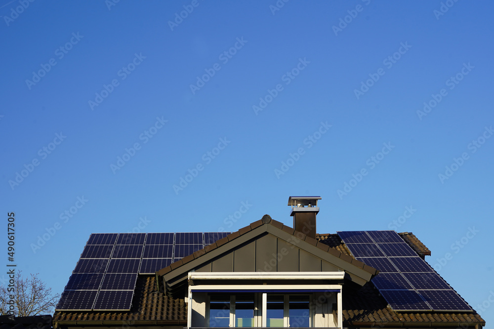 Modernes Wohnhaus mit Maximum an Solarpanelen auf dem neuen Dach. Zentral erhebt sich eine grosse Dachgaube. 