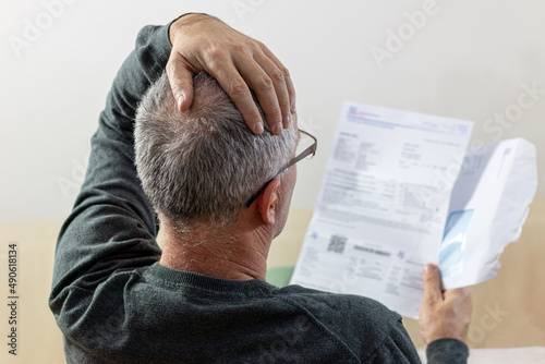 Fotografering Worried   middle-aged man reading unexpected news in paper document