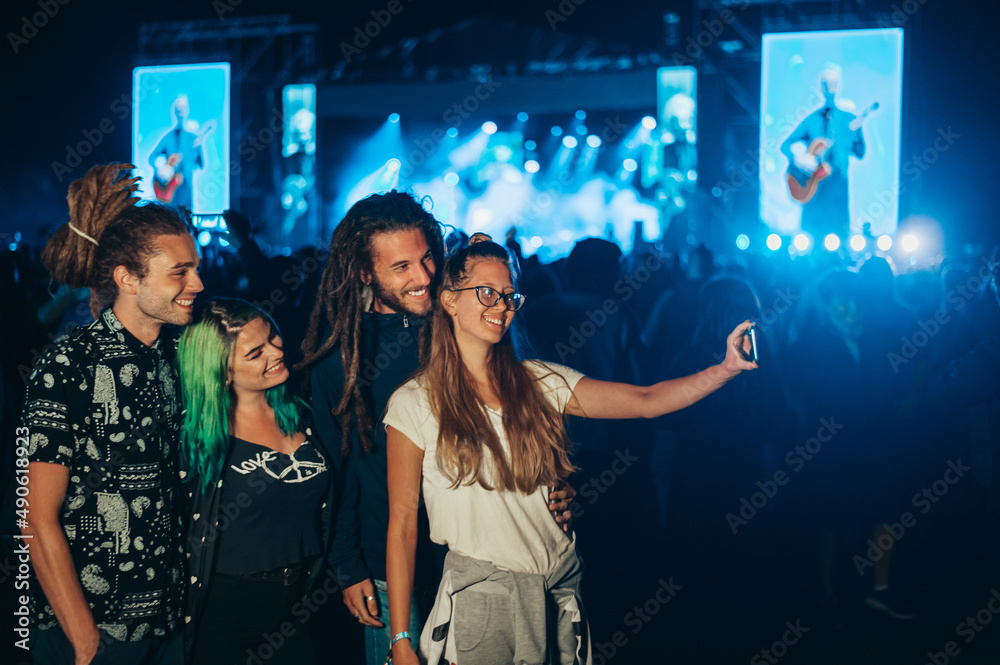 Friends at summer music festival taking selfie with a smartphone
