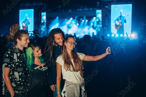 Friends at summer music festival taking selfie with a smartphone