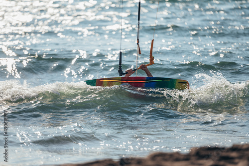 Woman holding kiteboard and going into the water