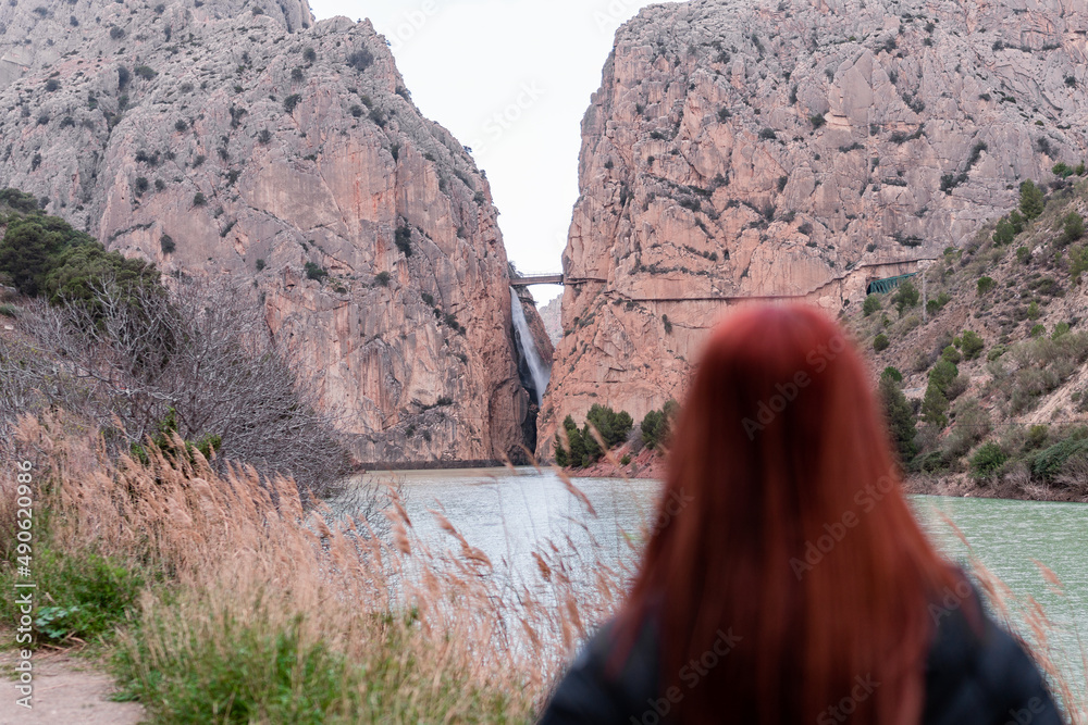 Fototapeta premium woman observes mini waterfall between two mountains