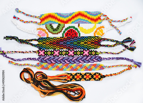 Woven DIY friendship bracelets handmade of embroidery bright thread with knots on white background